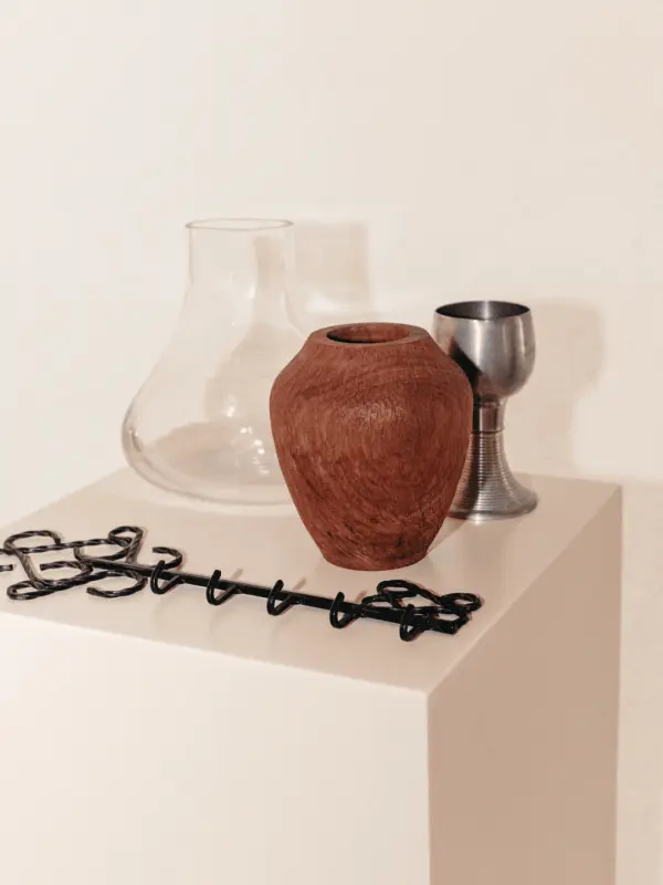 Objets décoratifs en céramique et métal présentés sur un socle blanc