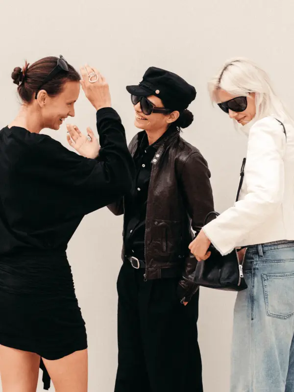 Trois personnes portant des tenues noires et blanches dans un style mode parisien